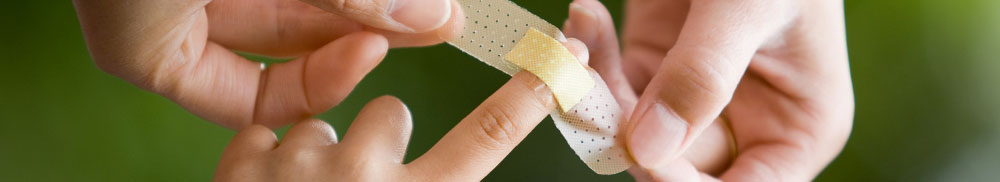 Picture - Nurse applying a band-aid to a child's finger